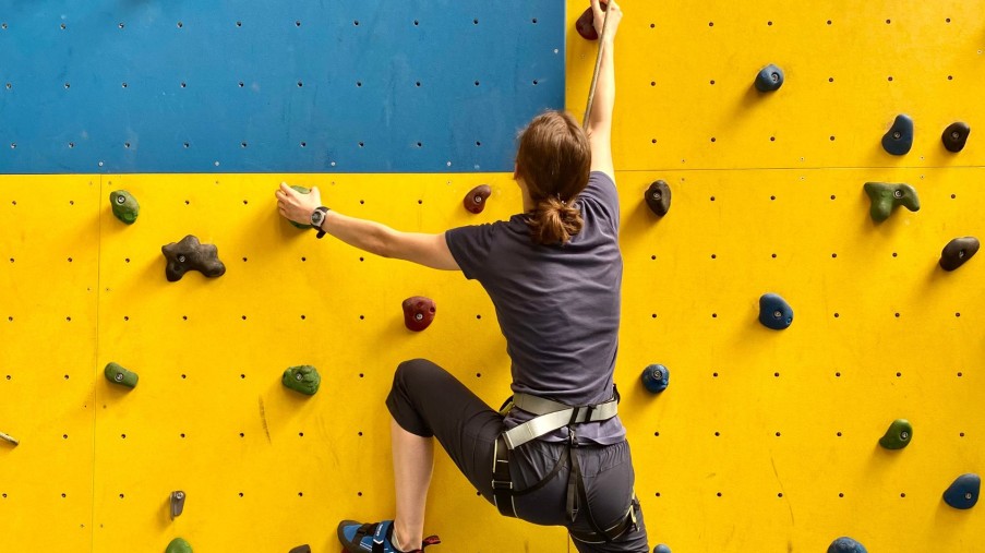 Das Bild zeigt eine Person an der Kletterwand.