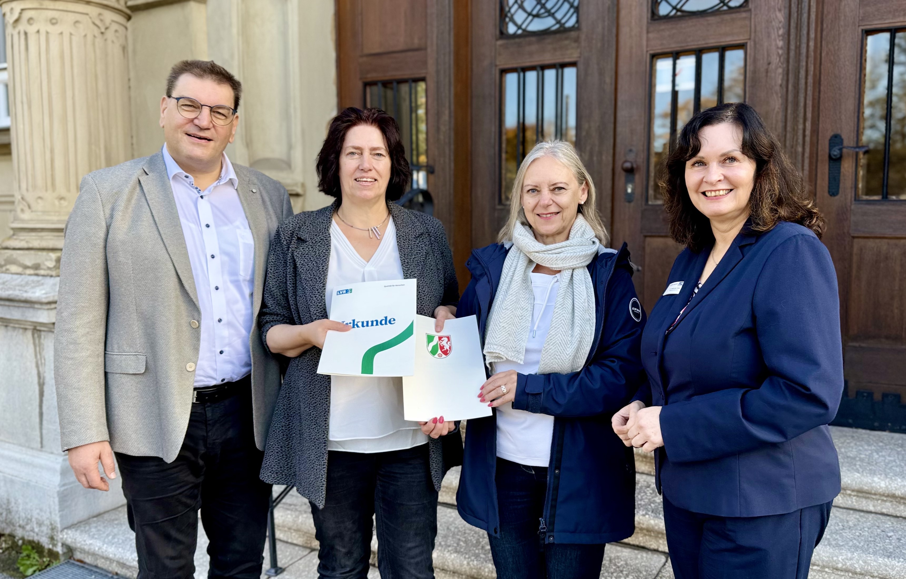 Vier Personen stehen nebeneinander